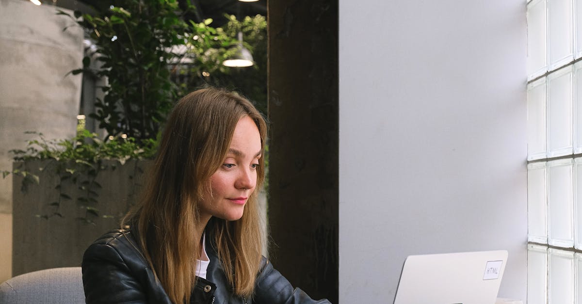 Woman freelancer using laptop indoors in a stylish office setting with natural light.